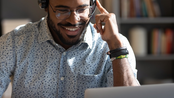 A man using a laptop with headphones on